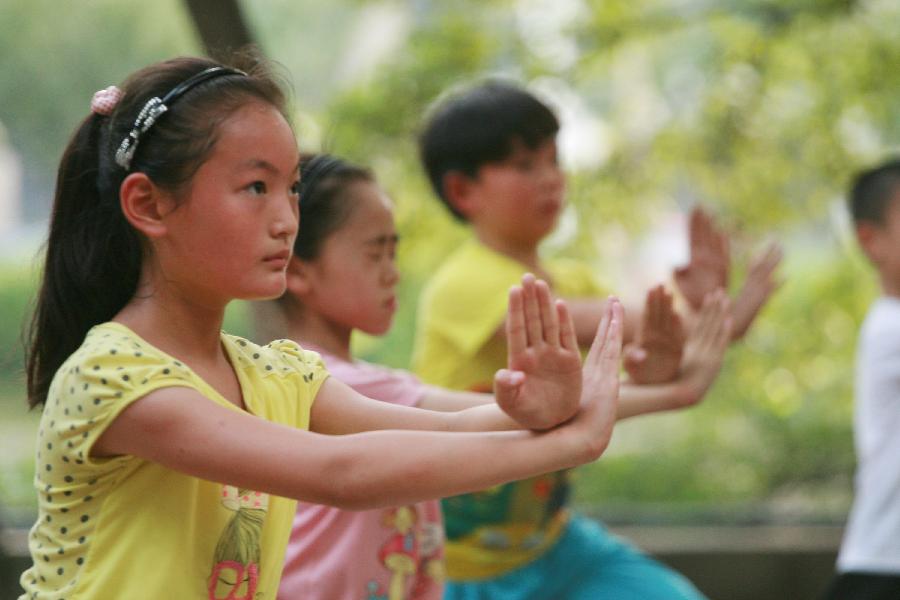 Children practise martial arts during their summer vacation in Nantong City, east China's Jiangsu Province, July 7, 2013. (Xinhua/Cui Genyuan)