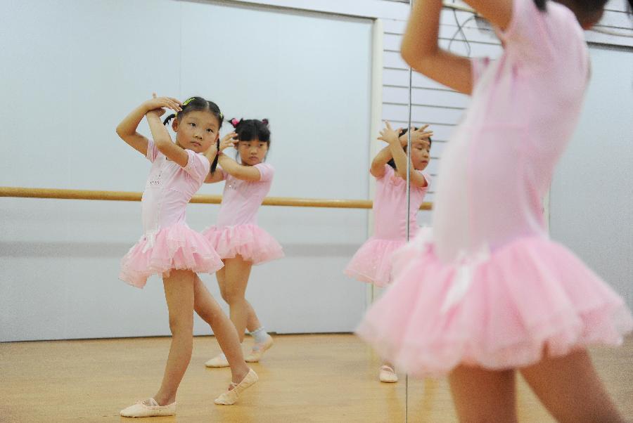 Young girls practise dance at a dance training class during the summer vacation in Shanghai, east China, July 7, 2013. (Xinhua/Lai Xinlin)