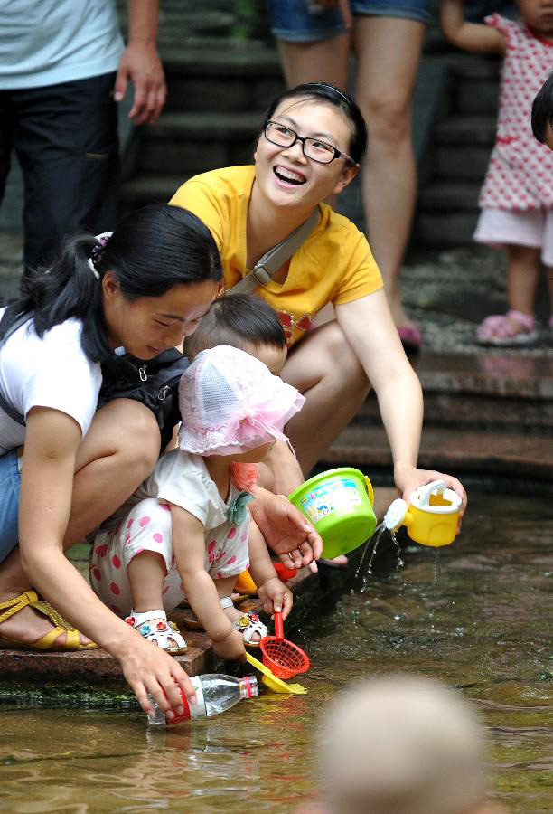 Citizens spend time in waterside leisure zone to beat the heat in the Wulongtan Park in Jinan, capital of east China's Shandong Province, July 8, 2013. The highest temperature in urban Jinan hit 35 degrees Celsius on Monday. (Xinhua/Xu Suhui)