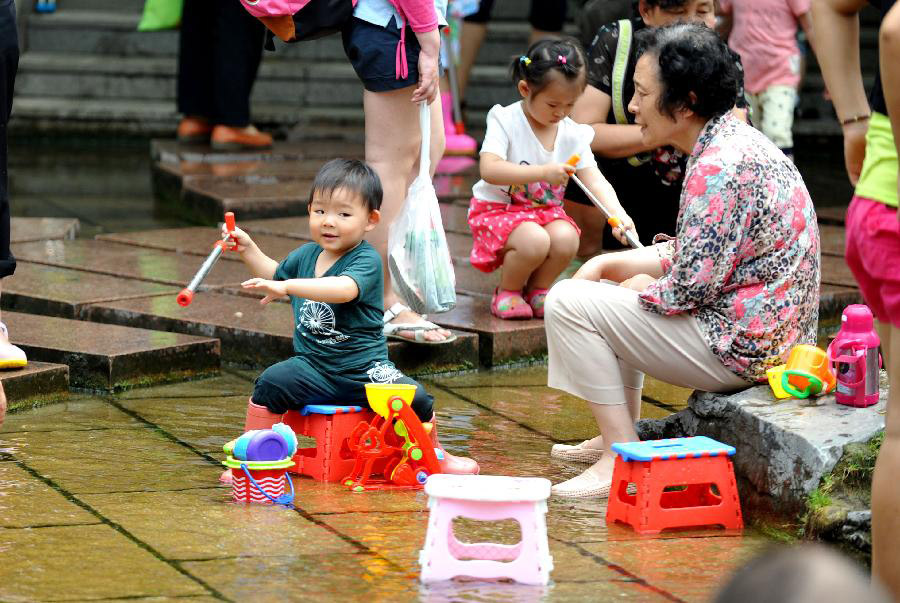 A child enjoy himself in waterside leisure zone to beat the heat in the Wulongtan Park in Jinan, capital of east China's Shandong Province, July 8, 2013. The highest temperature in urban Jinan hit 35 degrees Celsius on Monday. (Xinhua/Xu Suhui)