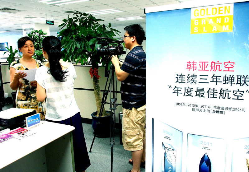 An employee (left) is interviewed at Asiana Airlines’ office in Shanghai, east China, July 7, 2013. (Xinhua/Chen Fei)