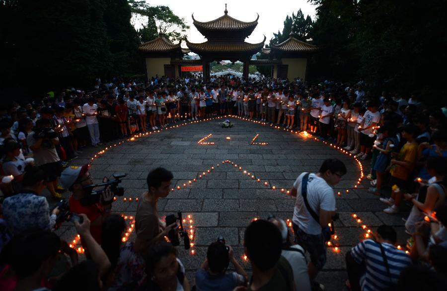People light candles during a commemorating ceremony to mourn the death of Wang Jialin and Ye Mengyuan, two young girls killed in a crash landing of an Asiana Airlines Boeing 777 at San Francisco airport, in Jiangshan City, east China's Zhejiang Province, July 8, 2013. Local residents gathered at Xujiang Park in Jiangshan to show their grief to the 17-year-old Wang and 16-year-old Ye, who were students from Jiangshan High School. (Xinhua/Han Chuanhao)