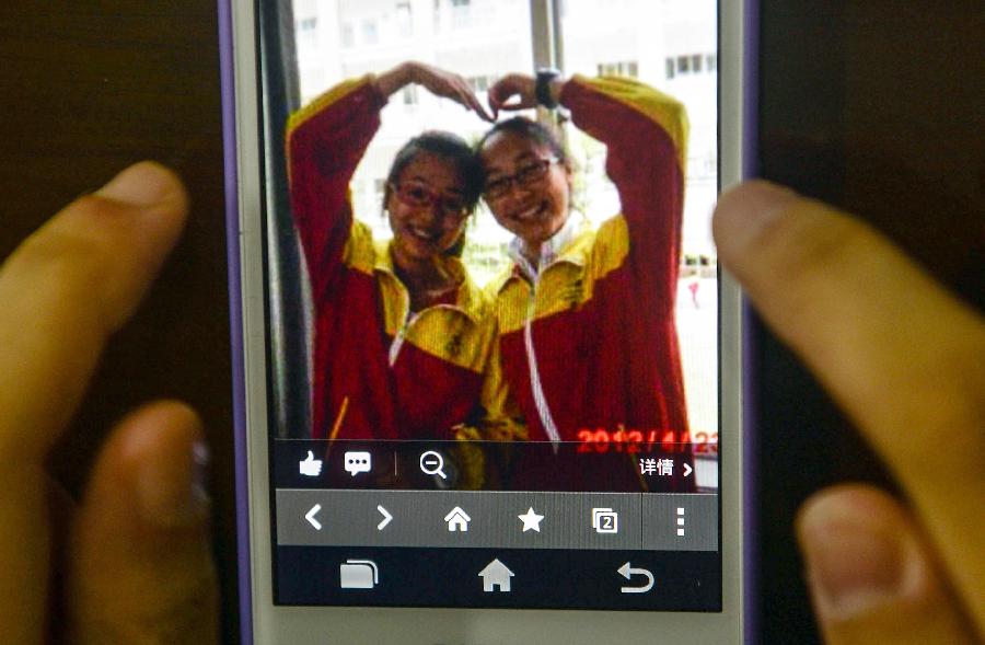 Photo taken on July 8, 2013 shows a picture of Wang Linjia (R) and Ye Mengyuan on a mobile phone, at Jiangshan Middle School in Jiangshan, east China's Zhejiang Province. Two Chinese passengers, Wang Linjia and Ye Mengyuan, were killed in a crash landing of an Asiana Airlines Boeing 777 at the San Francisco airport on Saturday morning. The two girls are both students of Jiangshan Middle School. Their family members headed for the United States on Monday.(Xinhua/Han Chuanhao) 