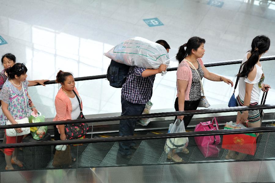 Passengers enter the Yinchuan Railway Station in Yinchuan, capital of northwest China's Ningxia Hui Autonomous Region, July 8, 2013. China's summer railway travel rush officially started on July 1 and will last until Aug. 31. (Xinhua/Peng Zhaozhi)