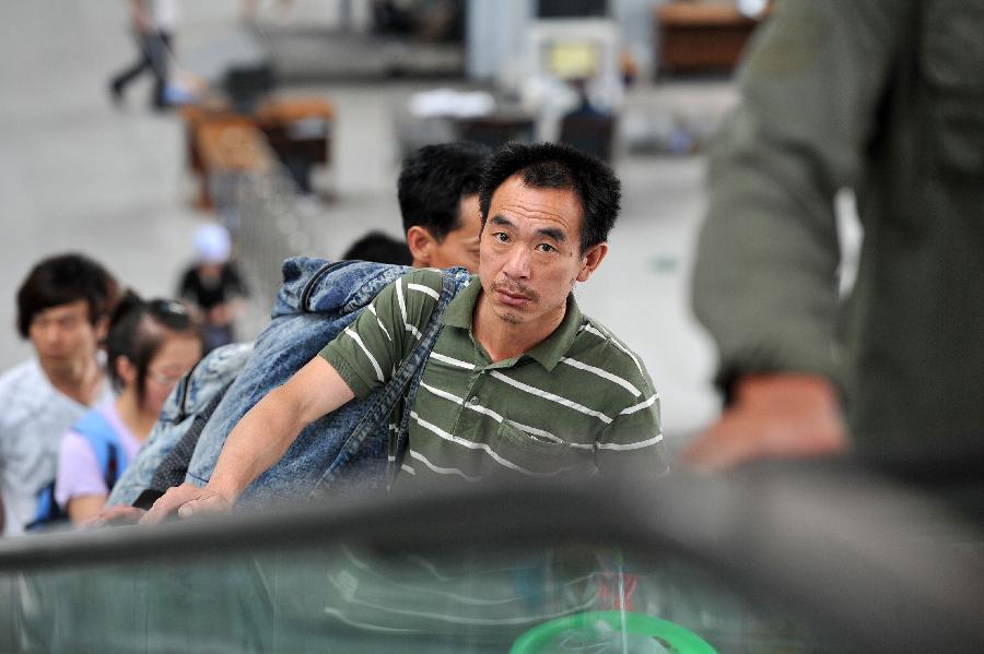 Passengers enter the Yinchuan Railway Station in Yinchuan, capital of northwest China's Ningxia Hui Autonomous Region, July 8, 2013. China's summer railway travel rush officially started on July 1 and will last until Aug. 31. (Xinhua/Peng Zhaozhi)