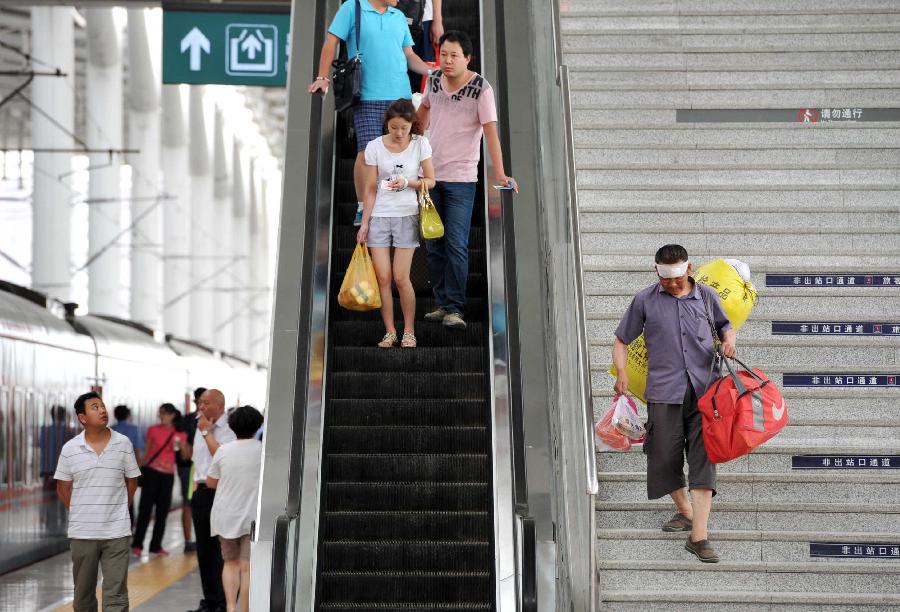 Passengers go to the platform at the Yinchuan Railway Station in Yinchuan, capital of northwest China's Ningxia Hui Autonomous Region, July 8, 2013. China's summer railway travel rush officially started on July 1 and will last until Aug. 31. (Xinhua/Peng Zhaozhi) 