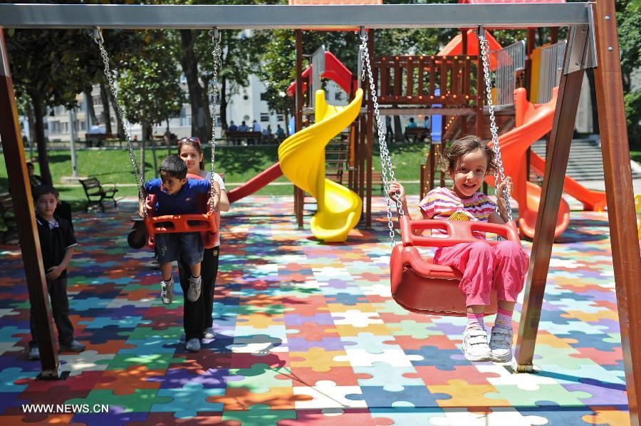 Children play in the Gezi park in Istanbul on July 8, 2013. Turkey's Gezi Park was opened to the public Monday after a week-long closure, Istanbul Governor Huseyin Avni Mutlu announced. (Xinhua/Lu Zhe)