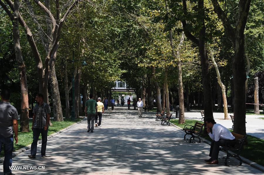 People walk in the Gezi park in Istanbul on July 8, 2013. Turkey's Gezi Park was opened to the public Monday after a week-long closure, Istanbul Governor Huseyin Avni Mutlu announced. (Xinhua/Lu Zhe)