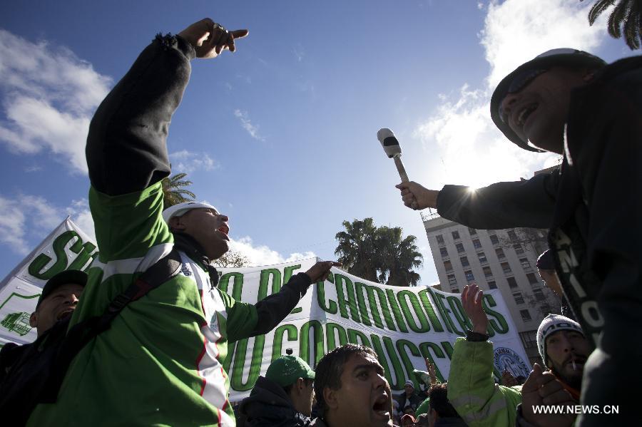 Workers from the truck driver union shout slogans during a protest and 24-hour strike, in Buenos Aires, capital of Argentina, on July 8, 2013. Truck drivers protesting for the high taxes on salaries stopped the cargo transport of Argentina, affecting the port activity, acording to local press. (Xinhua/Martin Zabala)