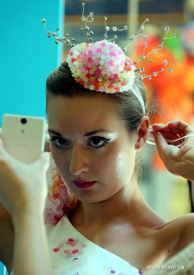 A model presents a headwear made of candies designed by Hong Kong designer Lilian Kan at Citygate Outlets in south China's Hong Kong, July 8, 2013. Kan showed her self-designed shoes and apparels made of candies here on Monday. (Xinhua/Li Peng)