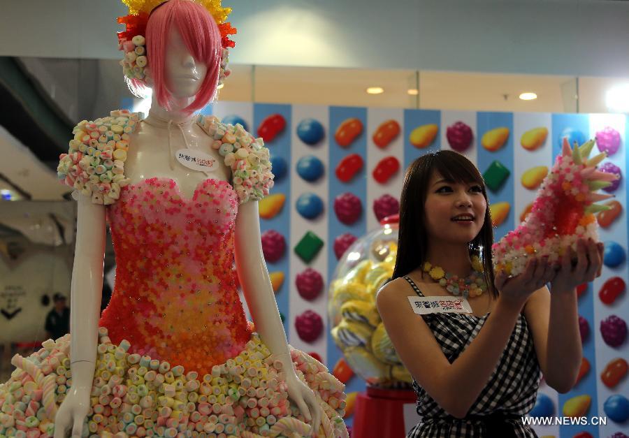 Lilian Kan (R), a Hong Kong designer, presents her candy dress and shoes at Citygate Outlets in south China's Hong Kong, July 8, 2013. Kan showed her self-designed shoes and apparels made of candies here on Monday. (Xinhua/Li Peng)