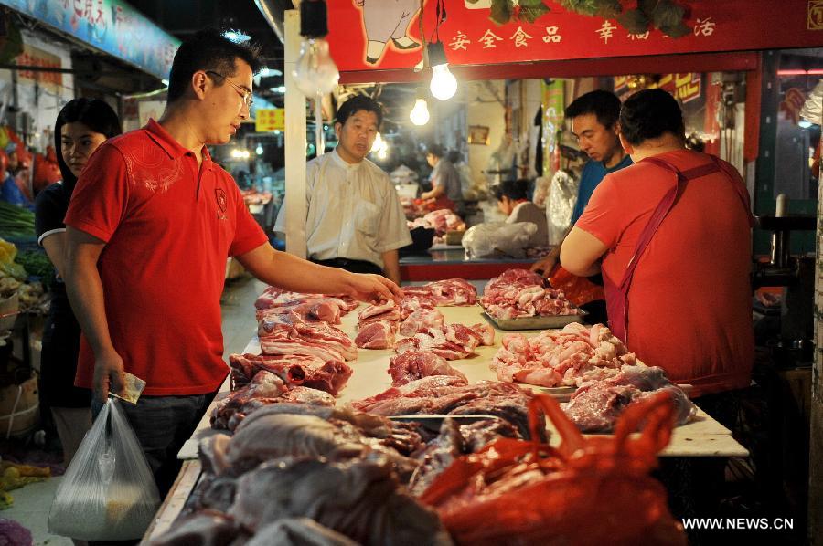 A citizen selects meat at a market in Changchun, capital of northeast China's Jilin Province, July 9, 2013. China's consumer price index (CPI), a main gauge of inflation, grew 2.7 percent year on year in June, up from 2.1 percent in May, the National Bureau of Statistics said on Tuesday. (Xinhua/Zhang Nan) 