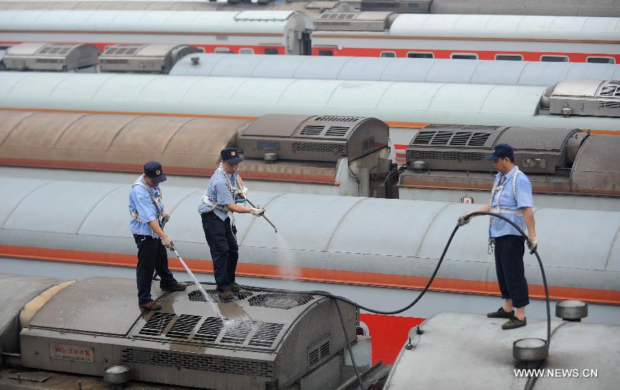 Staff members from the maintenace crew clean a train in Chengdu, capital of southwest China's Sichuan Province, July 8, 2013. Known as the "Train Hospital", the maintenance crew provide 24-hour-services for examining and cleaning trains. (Xinhua/Xue Yubin)