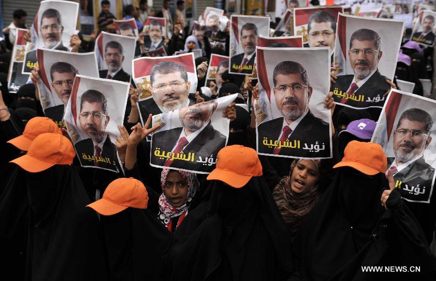 Yemeni protesters hold posters of ousted Egyptian President Mohamed Morsi during a rally at al-Tahrir Square in Sanaa, Yemen, on July 8, 2013. Thousands of Yemeni supporters of Mohamed Morsi took to streets to condemn Egyptian army's ouster of president.(Xinhua/Mohammed Mohammed)