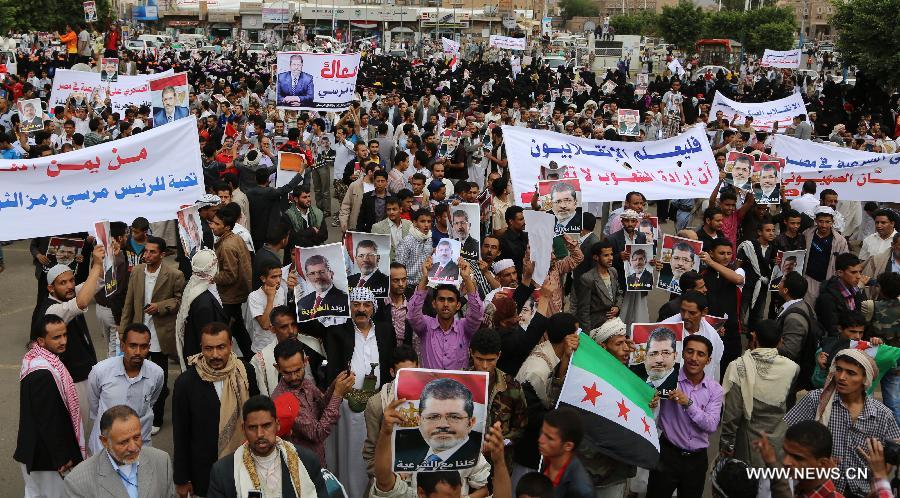 Yemeni protesters hold posters of ousted Egyptian President Mohamed Morsi during a rally at al-Tahrir Square in Sanaa, Yemen, on July 8, 2013. Thousands of Yemeni supporters of Mohamed Morsi took to streets to condemn Egyptian army's ouster of president. (Xinhua/Mohammed Mohammed)