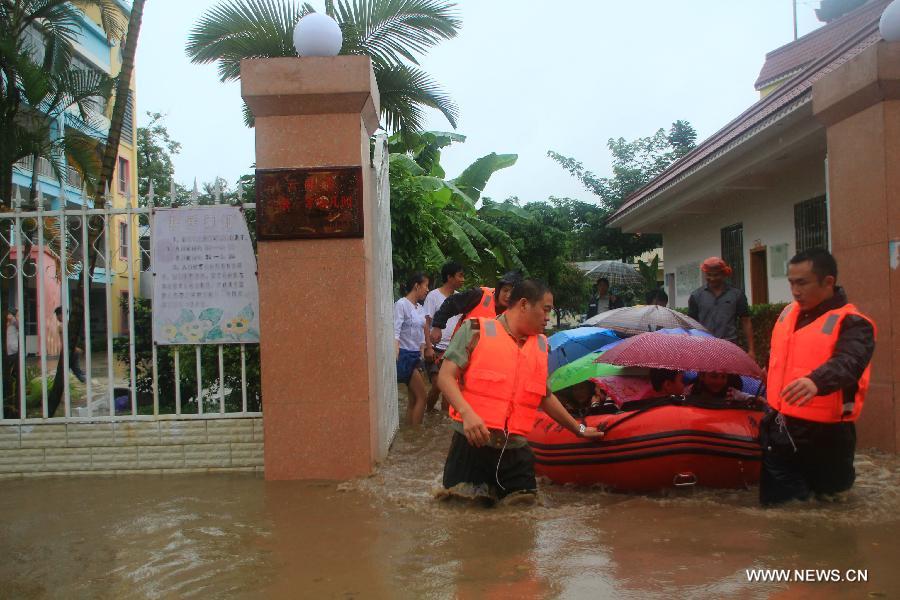 Officers transfer children with a kayak at a kindergarten in Yingjiang County, southwest China's Yunnan Province, July 8, 2013. Rainstorm-triggered floods have affected about 4,882 people in the county, causing damages to local agriculture and houses. The rescue operation is under way. (Xinhua)