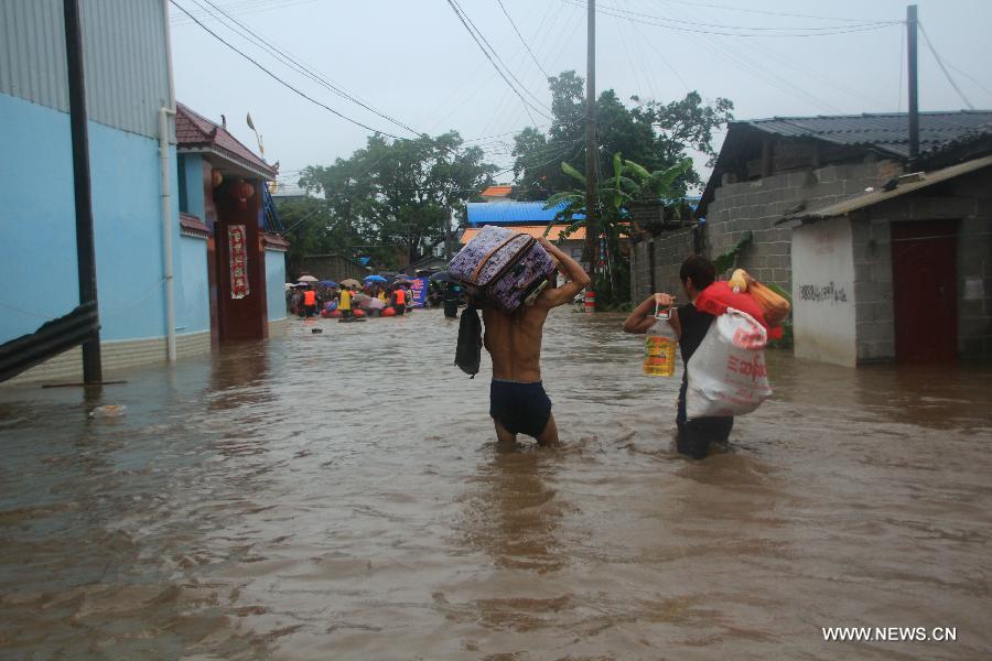 Local residents transfer materials from their flooded houses in Yingjiang County, southwest China's Yunnan Province, July 8, 2013. Rainstorm-triggered floods have affected about 4,882 people in the county, causing damages to local agriculture and houses. The rescue operation is under way. (Xinhua)