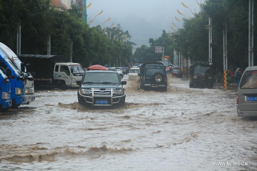Vehicles move in the intersection of Munao Zongge Road and Baoyuan Street in Yingjiang County, southwest China's Yunnan Province, July 8, 2013. Rainstorm-triggered floods have affected about 4,882 people in the county, causing damages to local agriculture and houses. The rescue operation is under way. (Xinhua)