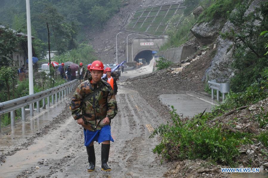 Communication emergency workers walk into rainstorm-hit Beichuan Qiang Autonomous County, southwest China's Sichuan Province, July 9, 2013. Downpours have submerged the quake-razed old town ruins of Beichuan, which was hit by an 8.0-magnitude earthquake in May 2008. (Xinhua)
