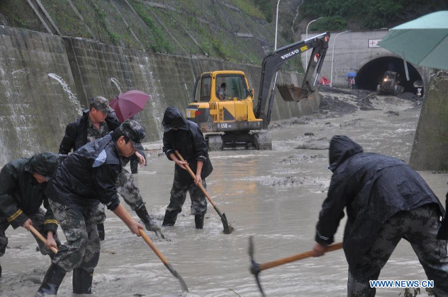 Rescuers open up flooded-road near Shilibei tunnel on 302 provincial road in Beichuan Qiang Autonomous County, southwest China's Sichuan Province, July 9, 2013. Downpours have submerged the quake-razed old town ruins of Beichuan, which was hit by an 8.0-magnitude earthquake in May 2008. (Xinhua)