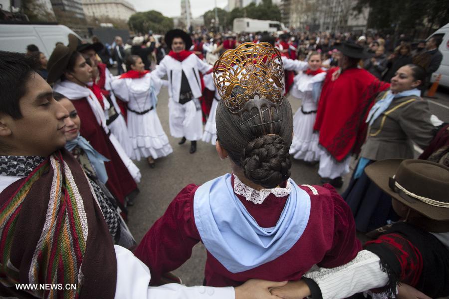 Couples dressed with traditional costumes dance a "Pericon", a typical Argentinean dance, during a parade during the celebration of Independence Day, in Buenos Aires, Argentina, on July 9, 2013.(Xinhua/Martin Zabala)