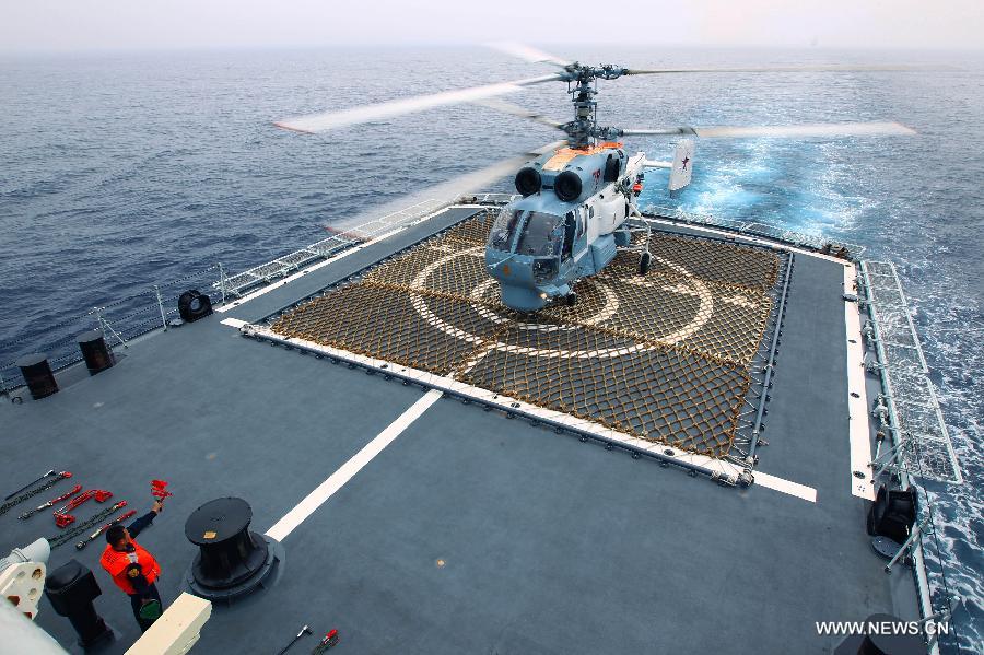 A Russian ship-borne helicopter lands on a Chinese naval vessel during the "Joint Sea-2013" drill at Peter the Great Bay in Russia, July 9, 2013. Chinese and Russian warships carried out a variety of exercises including joint air defense, maritime supply, joint escort and the rescue of hijacked vessels during the second day of "Joint Sea-2013" drill. (Xinhua/Zha Chunming)