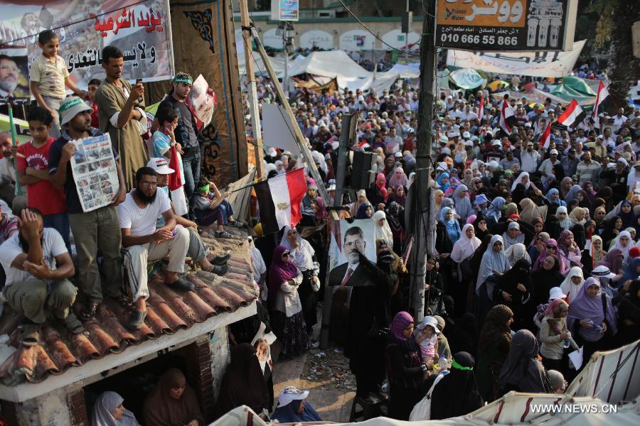 Egyptian supporters of ousted president Mohamed Morsi rally during a funeral of protesters killed on the previous day, outside Cairo's Rabaa al-Adawiya mosque on July 9, 2013. Clashes between Islamist protesters and the army in Cairo on July 9 killed at least 51 and injured 435 others. (Xinhua/Wissam Nassar) 