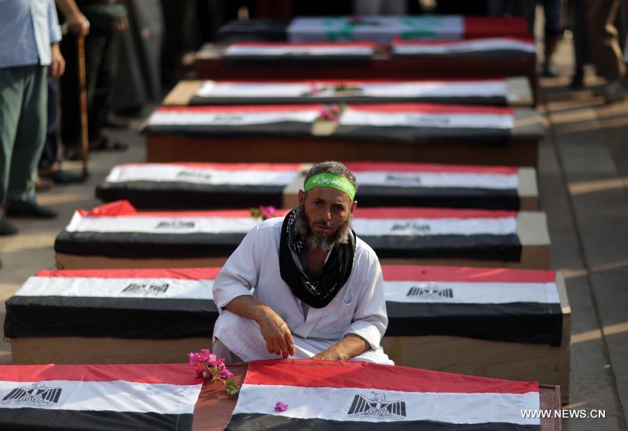 A supporter of ousted president Mohamed Morsi sits next to coffins, one day after fellow protesters were killed in clashes, inside Rabaa al-Adawiya mosque in Cairo, July 9, 2013. Clashes between Islamist protesters and the army in Cairo on July 9 killed at least 51 and injured 435 others. (Xinhua/Wissam Nassar) 