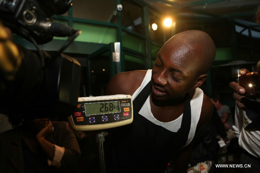 A member of Sauti Sol team looks at the result during a burger challenge at Brew Bistro in Nairobi, capital of Kenya, July 9, 2013. Four contestants had one hour to finish a 5kg burger with beef, two huge burger buns and 40 toppings. Sauti Sol team won the burger challenge. (Xinhua/Meng Chenguang)