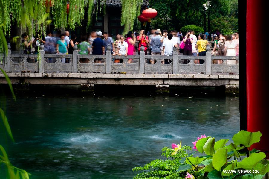Visitors enjoy the scenery of Baotu Spring in Jinan, capital of east China's Shandong Province, July 9, 2013. The undergroud water level of the Baotu Spring, a famous scenic spot in Jinan, has dropped to 28.11 meters, lower than the yellow warning line of 28.15 meters. (Xinhua/Guo Xulei) 