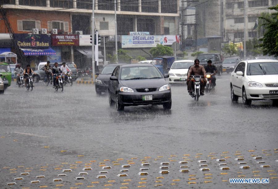 Vehicles run on a road during the heavy rain in eastern Pakistan's Lahore, July 9, 2013. Four people were killed and three others injured when a two-storey house collapsed due to heavy rainfall in Gujranwala city, near Lahore, in eastern Pakistan's Punjab province, local media reported Tuesday. (Xinhua/Sajjad)