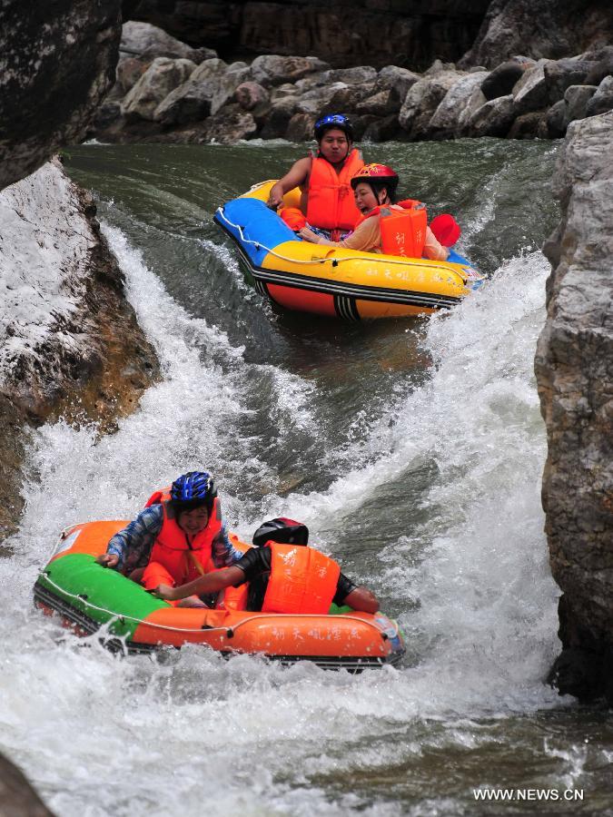 Tourists raft on the water at the Chaotianhou scenery spot in Xingshan County, central China's Hubei Province, July 9, 2013. Large number of tourists headed for Chaotianhou to raft due to the lingering heat wave recently in the province. (Xinhua/Du Huaju)