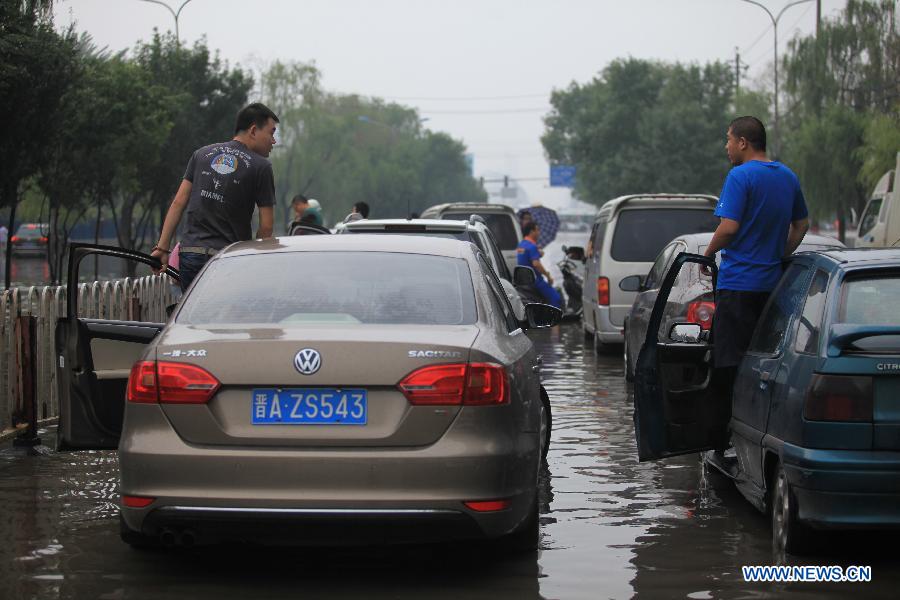 The traffic is disrupted on the flooded Nanneihuan Street in Taiyuan City, capital of north China's Shanxi Province, July 9, 2013. A heavy rainfall hit many regions of Shanxi Province on Tuesday. Parts of Taiyuan City was seriously flooded and the traffic was disrupted. (Xinhua/Shi Xiaobo)