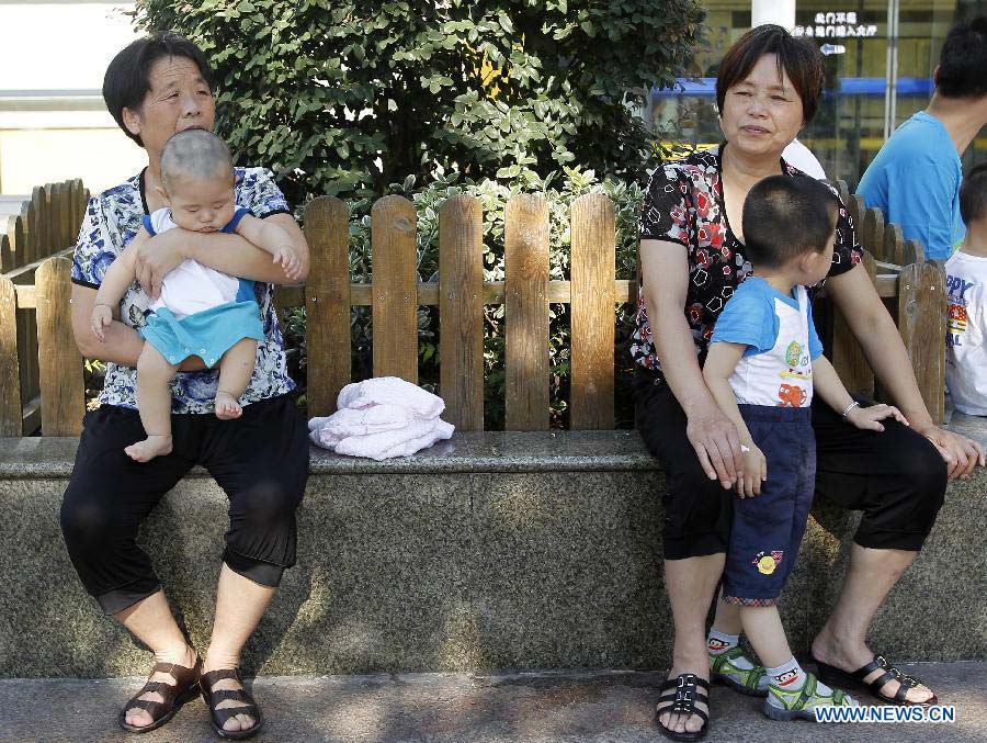 Children accompanied by relatives wait for treatment at the Children's Hospital Affiliated to Fudan University, in Shanghai, east China, July 10, 2013. Due to the sustained high temperatures and the summer vacation, the daily outpatient number stood at 7,500 to 8,500 since June 21. (Xinhua/Ding Ting)
