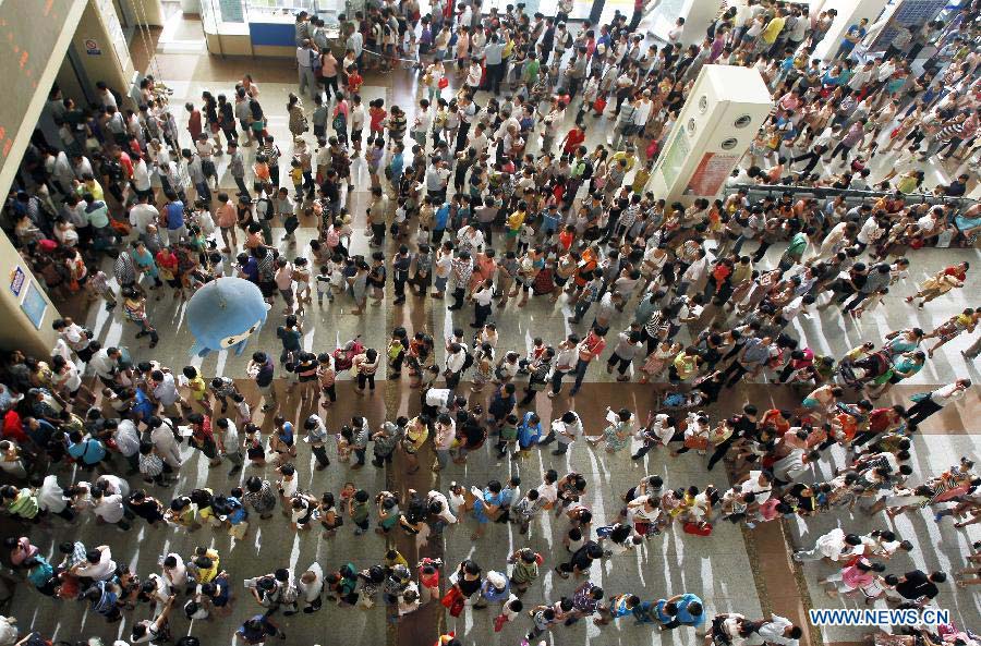 Parents queue to register for their children at the Children's Hospital Affiliated to Fudan University, in Shanghai, east China, July 10, 2013. Due to the sustained high temperatures and the summer vacation, the daily outpatient number stood at 7,500 to 8,500 since June 21. (Xinhua/Ding Ting)