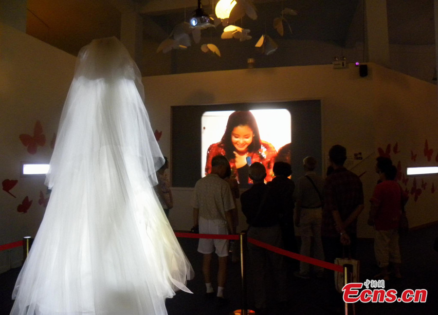  An exhibition displaying the albums, clothes and other belongings of late Taiwanese singer Teresa Teng in eastern China's Jiangsu province has attracted more than 20,000 visitors by July 9, 2013. Visitors watch a video record of Teng. [Photo: CNS/Huang Ying] 