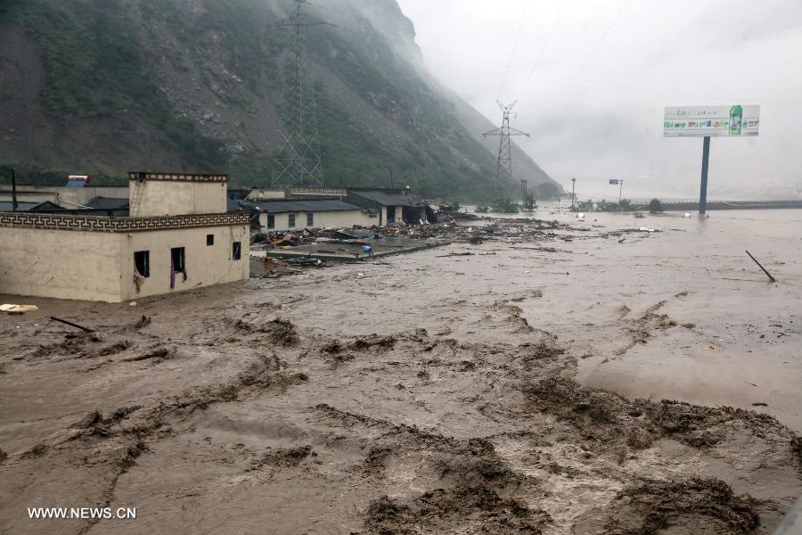 A bridge is flooded in Miansi Township of Wenchuan County, southwest China's Sichuan Province, July 10, 2013. Rainstorms battered the county in these two days. (Xinhua/Lu Guotong)