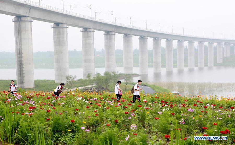 Tourists visit the Garden Expo Park in Beijing, capital of China, July 9, 2013. The 9th China (Beijing) International Garden Expo is held here from May 18 to Nov. 18, 2013. (Xinhua/Wang Xibao)