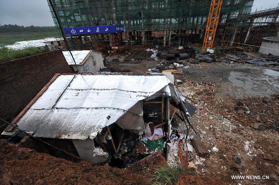 Photo taken on July 10, 2013 shows the collapsed wall and make-shift houses at a construction site of a coal cleaning plant of Dacheng Liyuan Coalification Co., Ltd at Pingshu Village of Pingshu Township in Shouyang County, north China's Shanxi Province, July 10, 2013. Twelve construction workers were killed and seven others injured after their make-shift house was buried by a collapsed wall on Tuesday evening. Rescue work has ended by Wednesday morning. (Xinhua/Zhan Yan)