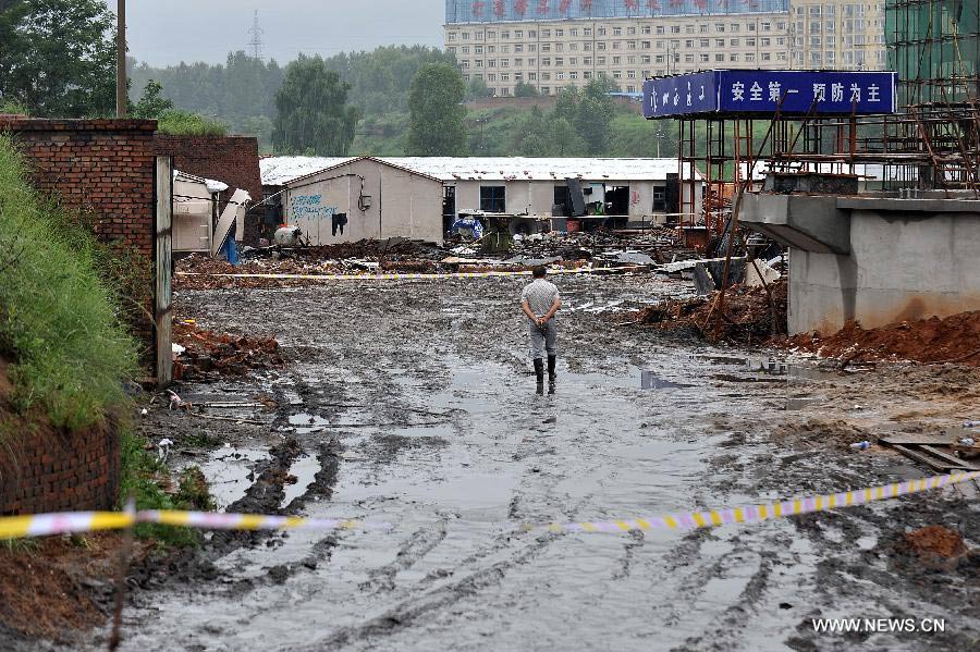 A worker stands by the collapsed make-shift houses of a coal cleaning plant of Dacheng Liyuan Coalification Co., Ltd at Pingshu Village of Pingshu Township in Shouyang County, north China's Shanxi Province, July 10, 2013. Twelve construction workers were killed and seven others injured after their make-shift house was buried by a collapsed wall on Tuesday evening. Rescue work has ended by Wednesday morning. (Xinhua/Zhan Yan)
