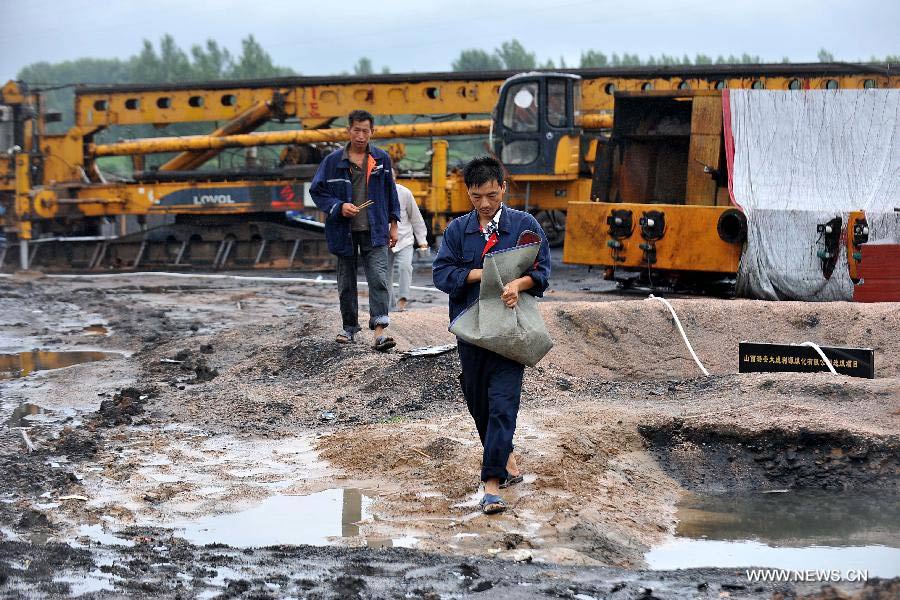 Workers walk in the construction site of a coal cleaning plant of Dacheng Liyuan Coalification Co., Ltd at Pingshu Village of Pingshu Township in Shouyang County, north China's Shanxi Province, July 10, 2013. Twelve construction workers were killed and seven others injured after their make-shift house was buried by a collapsed wall on Tuesday evening. Rescue work has ended by Wednesday morning. (Xinhua/Zhan Yan)