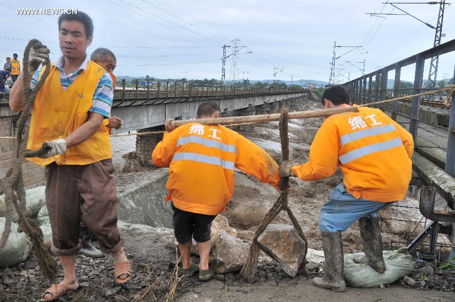 Workers repair the parapet wall, which was destroyed by rainstorm-triggered flood, of the upline of the Mianyuan River Bridge of the Baoji-Chengdu Railway in southwest China's Sichuan Province, July 10, 2013. The upline of the bridge has been closed while the downlink remained open for railway traffic. (Xinhua/Wang Zhengwei)