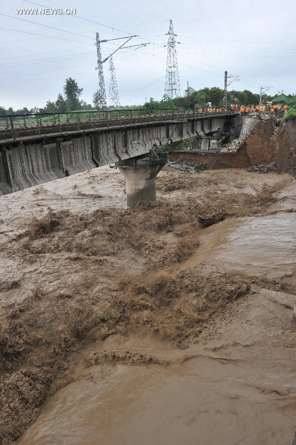 Floods flow through the Mianyuan River Bridge of the Baoji-Chengdu Railway in southwest China's Sichuan Province, July 10, 2013. Severe rainstorms battered the region these days. (Xinhua/Wang Zhengwei)