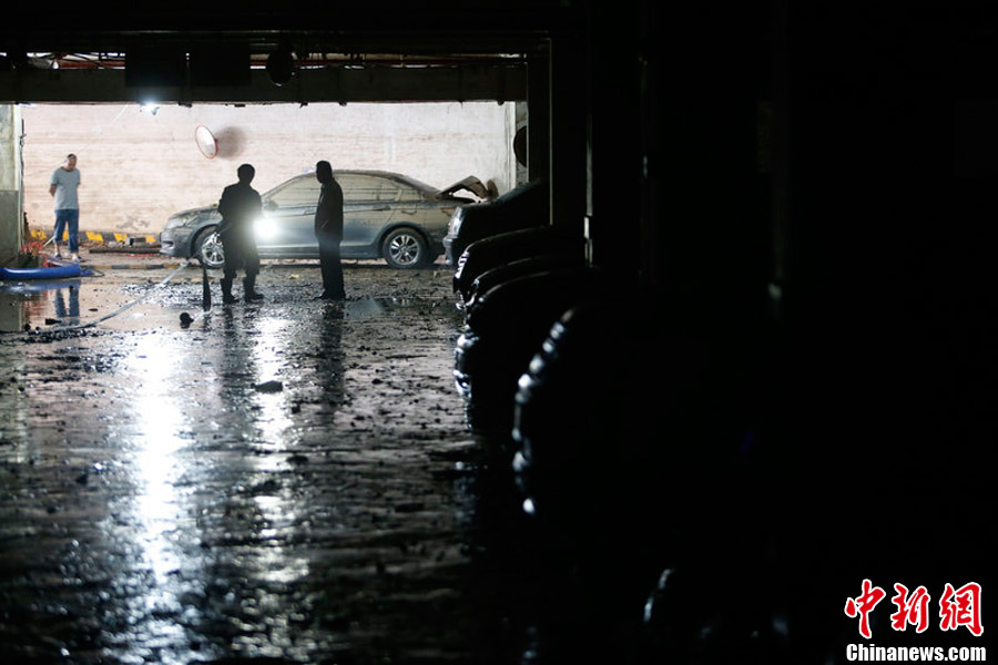 It has been four days since the torrential rains pounded the city, but car owners’ efforts to save their flooded cars in underground garages were not still underway. (Photo/CNS)