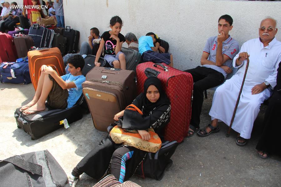 Palestinian passengers wait outside the departure lounge at Rafah crossing point with Egypt in the southern Gaza Strip on July 10, 2013. Egypt reopened the main crossing point of the Gaza Strip temporarily after six days of consecutive closure. Ghazi Hamad, Hamas's deputy foreign minister, said the crossing would remain open for a few hours on Wednesday so Palestinians could return and so foreigners, patients due to receive medical treatment in Cairo and Palestinians with residency permits in third countries could leave the Gaza Strip. (Xinhua/Khaled Omar)