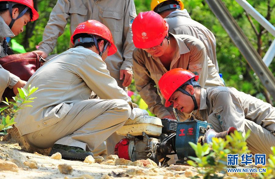 Workers with Transmission and Distribution Engineering Company of Fujian Province brave the heat and debug the powered devices in Xiamen, southeast China's Fujian province on July 4, 2013. (Photo/Xinhua)