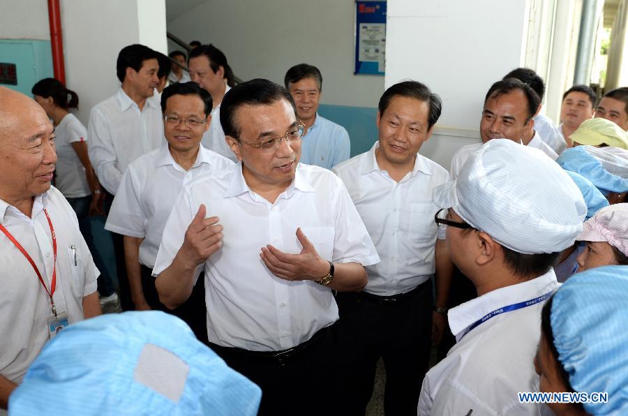 Chinese Premier Li Keqiang (C) talks with employees while visiting a company in Beihai, south China's Guangxi Zhuang Autonomous Region, July 8, 2013. Li made a research tour in Guangxi from July 8 to 10. (Xinhua/Ma Zhancheng)