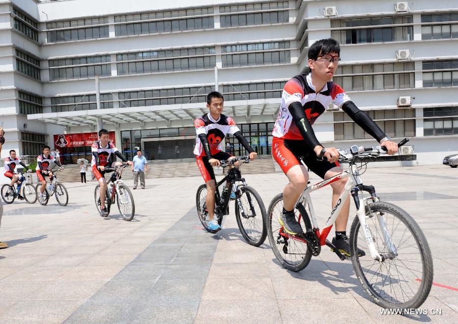 Cyclists ride around the campus before their expedition in Nanjing, capital of east China's Jiangsu Province, July 10, 2013. In celebration of the 60th anniversary of the founding of Nanjing University of Science and Technology(NUST), 15 students were selected to participate in a bike riding activity from Nanjing to Harbin where the old campus site was located. The roots of NUST can be traced back to 1952 when an institute of Military Engineering of the PLA was established. (Xinhua/Sun Can)