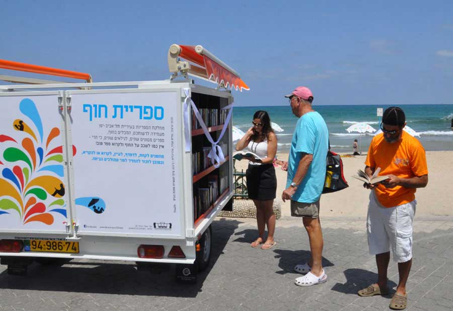 People read books from a beach library in Tel Aviv-Yafo on Tuesday, July 9, 2013. [Photo: CRIENGLISH.com / Zhang Jin]