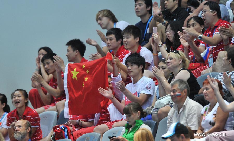 Spectators wave the Chinese national flag during the final of men's 10m platform diving at the 27th Summer Universiade in Kazan, Russia, July 10, 2013. China's Huo Liang won the gold medal with 531.25. (Xinhua/Kong Hui)